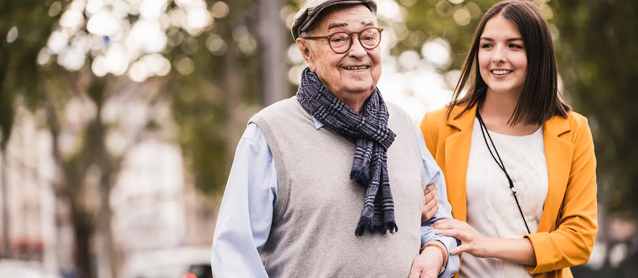 Eine junge Dame begleitet einen älteren Herren